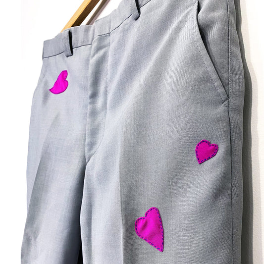 bright pink hearts hand sewn on grey dress pants