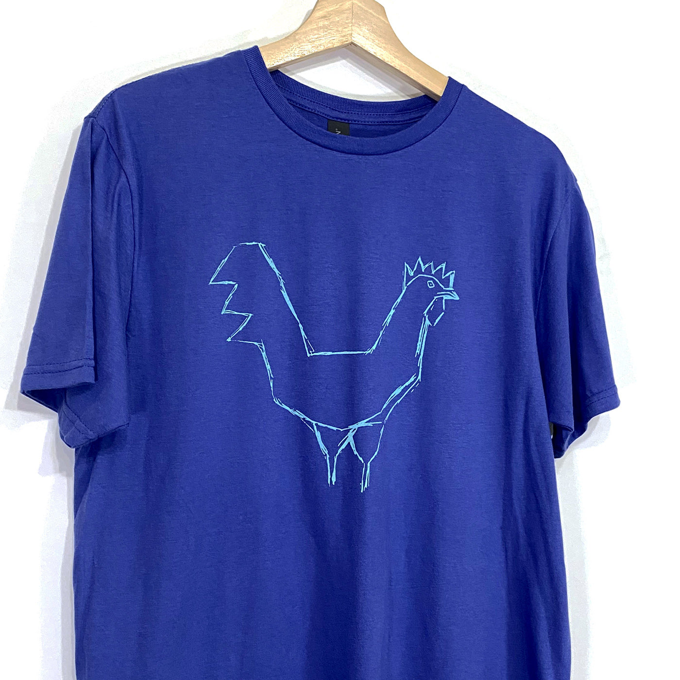 A rough drawing of a chicken silkscreen on a royal blue short sleeved tee with a crew neck