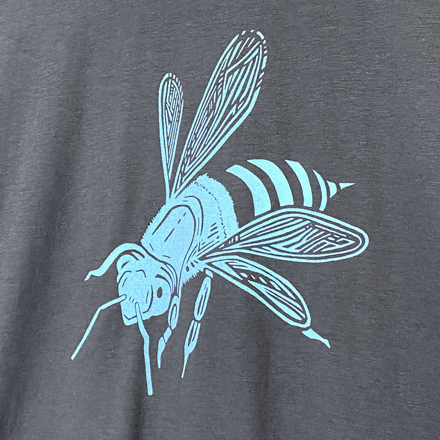Detail of a light blue bee drawing screen printed on the front of a grey shirt
